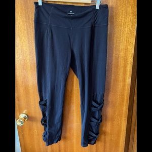 Black Athleta leggings with mesh crisscross panels on legs.